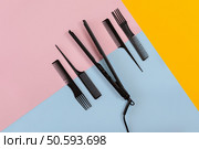 Various hair styling devices on the color blue, yellow, pink paper background, top view. Copy space. Still life. Mock-up. Flat lay. Various hair styling devices on the color blue, yellow, pink paper background, top view. Стоковое фото, агентство Ingram Publishing / Фотобанк Лори