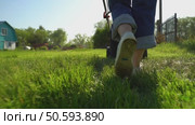 Woman with lawn mower in the garden. Стоковое видео, видеограф Igor Skripachev / Фотобанк Лори