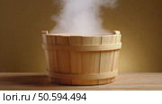 Hot water vapor emanating from wooden bucket on table. Стоковое AI-видео, аниматор Юрий Поздников / Фотобанк Лори