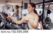 Young woman working out on elliptical machine. Стоковое видео, видеограф Яков Филимонов / Фотобанк Лори