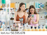 Daughter and mother in summer clothes scans code on toothbrush kit to check expiration date. Стоковое фото, фотограф Яков Филимонов / Фотобанк Лори