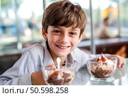 Веселый мальчик в кафе, вкусное угощение, мороженое. Стоковое AI-изображение, AI-художник Щеголева Ольга / Фотобанк Лори