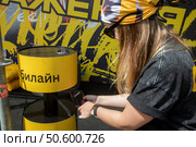 Девушка заряжает телефон от зарядной станции компании Билайн на молодежном фестивале в городе Москве, Россия. Редакционное фото, фотограф Николай Винокуров / Фотобанк Лори