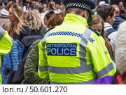 Uniformed Police Officer in Yellow Reflective Jacket Managing Crowd at Public Event (2024 год). Редакционное фото, фотограф Zydrius Tartenis / Фотобанк Лори