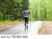 A man on a roller ski rides in the park.Cross country skilling. Стоковое фото, фотограф Александр Поташев / Фотобанк Лори