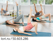Girls at group Hatha yoga class does preliminary preparatory stretching. Стоковое фото, фотограф Яков Филимонов / Фотобанк Лори