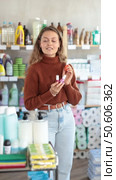 Selective young female customer choosing colorful nail polish in retail store. Стоковое видео, видеограф Яков Филимонов / Фотобанк Лори
