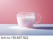 Pink drink with froth pouring sugar in a glass cup on pink and white background. Стоковое AI-изображение, AI-художник Иван Рябоконь / Фотобанк Лори