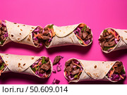 Delicious barbacoa beef wraps with fresh vegetables and herbs on vibrant pink background. Стоковое AI-изображение, AI-художник Иван Рябоконь / Фотобанк Лори