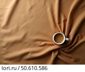 Warm cup of coffee sits on a textured brown fabric surface, showcasing cozy morning vibes and inviting relaxation during a tranquil moment. Стоковое AI-изображение, AI-художник Анна Сивакова / Фотобанк Лори