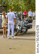 Молодая пара у мотоцикла на парковке в летний день. Редакционное фото, фотограф Владимир Шипикин / Фотобанк Лори
