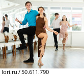 Cheerful young couple dancing vigorous lindy hop at group rehearsal. Стоковое фото, фотограф Яков Филимонов / Фотобанк Лори