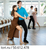 Guy enjoying impassioned merengue with female partner in dance class. Стоковое фото, фотограф Яков Филимонов / Фотобанк Лори