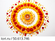 Vibrant flower rangoli with a burning diya, celebrating the spirit of diwali. Стоковое AI-изображение, AI-художник Иван Рябоконь / Фотобанк Лори