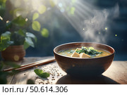 A steaming bowl of miso soup sits against a dark, moody backdrop, capturing its warm, inviting essence. The traditional broth, rich with umami, is a classic staple of Japanese cuisine. Стоковое AI-изображение, AI-художник Nart / Фотобанк Лори