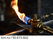 Gas burner emitting powerful jet of blue and orange flame. Стоковое AI-изображение, AI-художник Иван Рябоконь / Фотобанк Лори