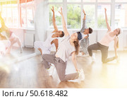 Girl and her students perform hip hop dance on one bent leg, movement in horizontal plane near floor. Стоковое фото, фотограф Яков Филимонов / Фотобанк Лори