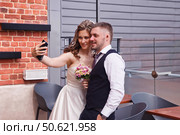 Couple Captures Joyful Moment Together in Modern Venue After Exchanging Vows. Стоковое фото, фотограф Aleksandr Golubev / Фотобанк Лори