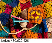 Crochet granny square, clews and hook on crochet blanket background photo. Стоковое фото, фотограф Елена / Фотобанк Лори