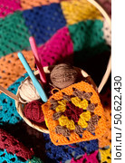 Crochet granny square, clews and hook on crochet blanket background photo. Стоковое фото, фотограф Елена / Фотобанк Лори