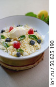 Granular cheese dessert drizzling golden honey, topped with fresh berries, mint, accompanied by smooth ice cream on pristine porcelain surface. Стоковое видео, видеограф Данил Руденко / Фотобанк Лори