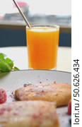 Ukrainian nalysnyky adorned with fresh raspberries and blueberries, sprinkled with powdered sugar, paired with orange juice on white plate. Стоковое видео, видеограф Данил Руденко / Фотобанк Лори