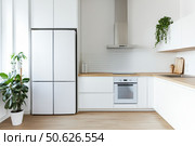 Modern trendy kitchen design with white cabinets. Subway tile backsplash, marble countertop. No brands or labels. Neutral contemporary design. Simply furniture with utensils, crockery, refrigerator. Стоковое AI-изображение, AI-художник Марина Демидюк / Фотобанк Лори