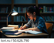 Ученица старших классов в библиотеке пишет в тетради. A high school student in the library is writing in a notebook. Стоковое AI-изображение, AI-художник Смирнова Светлана / Фотобанк Лори