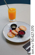 Ukrainian cottage cheese pancakes garnishing wooden board, surrounded by fresh strawberries, sour cream, orange juice near rustic linen tablecloth. Стоковое видео, видеограф Данил Руденко / Фотобанк Лори