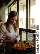 Enjoying a Delightful Sushi Feast With Friends in a Modern Eatery During a Sunny Afternoon. Стоковое фото, фотограф Aleksandr Golubev / Фотобанк Лори
