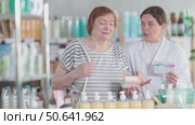 Woman choosing pills with help from pharmacist. Стоковое видео, видеограф Яков Филимонов / Фотобанк Лори