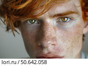 Portrait of young man showing his freckles and green eyes with red hair. Стоковое AI-изображение, AI-художник Иван Рябоконь / Фотобанк Лори