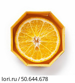 Fresh orange slice resting in octagonal cardboard container. Стоковое AI-изображение, AI-художник Иван Рябоконь / Фотобанк Лори