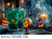 Two halloween cocktails burning with pumpkins and candles in a spooky atmosphere. Стоковое AI-изображение, AI-художник Иван Рябоконь / Фотобанк Лори