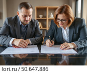 Деловые люди подписывают документы за столом в офисе / Business people sign documents at their desk in the office. Стоковое AI-изображение, AI-художник Валерий Лукин / Фотобанк Лори