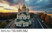 Aerial view of a beautiful Orthodox cathedral with golden domes, overlooking a city skyline at a dramatic sunset. Стоковое AI-видео, аниматор Sergey Grishin / Фотобанк Лори