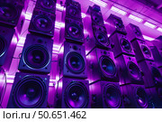 Wall of powerful audio speakers illuminated by purple lights creating an enthralling atmosphere. Стоковое AI-изображение, AI-художник Иван Рябоконь / Фотобанк Лори