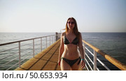 A woman goes swimming on a bridge in the sea. Стоковое видео, видеограф Igor Skripachev / Фотобанк Лори