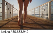 A woman goes swimming on a bridge in the sea. Стоковое видео, видеограф Igor Skripachev / Фотобанк Лори