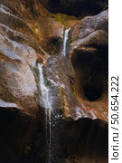 Streams of water flowing down a steep cliff with splashing. Picturesque background image. Fragment of a waterfall. Стоковое фото, фотограф Роман Дзюбало / Фотобанк Лори
