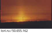 Vibrant sunset casting orange red hues across six landscape silhouettes, revealing urban structures and natural scenes against dimming evening sky, 8 mm film. Стоковое видео, видеограф Данил Руденко / Фотобанк Лори