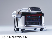 Modern defibrillator showing ekg rhythm on screen in hospital room. Стоковое AI-изображение, AI-художник Иван Рябоконь / Фотобанк Лори