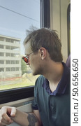 A man wearing sunglasses and a black shirt is sitting on a train. Стоковое видео, видеограф Ярославский Максим / Фотобанк Лори