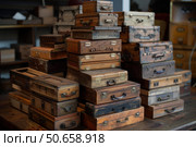 Stacks of vintage wooden boxes with metal handles creating nostalgic atmosphere. Стоковое AI-изображение, AI-художник Иван Рябоконь / Фотобанк Лори
