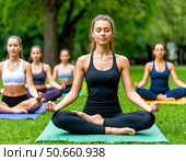 A group of women are sitting on the grass and meditating. Стоковое фото, фотограф Ярославский Максим / Фотобанк Лори