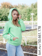 Smiling girl in green tracksuit on street looking at camera. Стоковое фото, фотограф Роготнева Виктория / Фотобанк Лори