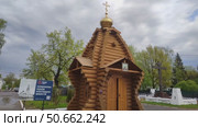 Православный храм-часовня на месте утраченного Спасо-Всеградского собора. Деревянная часовня Спаса Всемилостивого на площади Революции. На заднем плане Поклонный Крест. Россия, Вологда, 23 мая 2025. Редакционное видео, видеограф Ирина / Фотобанк Лори