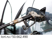 Gas station. Refueling a car with gasoline. Fuel dispenser in the car's fuel tank at a gas station. Rising fuel prices worldwide. Стоковое фото, фотограф Photojuli / Фотобанк Лори