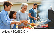 Happy multi-generational family having summer barbecue in backyard, grandmother, mother and daughter cooking together outdoors while man grills meat. Стоковое AI-изображение, AI-художник Павел Муравьев / Фотобанк Лори