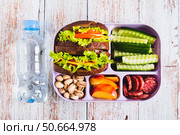 Close up lunch box with food, bottle of water on the table top view. Стоковое фото, фотограф Елена Руй / Фотобанк Лори
